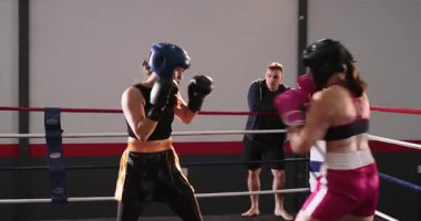 Pembe boksör, ringde koçun önünü kesiyor ve karşı atağa geçiyor. Atletik, dövüş, antrenman, fitness, kararlılık, dinamik, performans