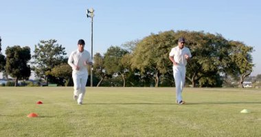 Koşu kursundan sonra Hintli koç kriket sahasında denge için erkek stajyer ayak hareketlerine rehberlik etti. Atletik, antrenman, incelik, koçluk, açık hava, canlı, takım çalışması