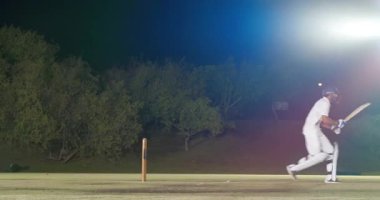 Kısa top kask vuruşu, Hintli vurucunun sahada yüzünü korumasına ve takım arkadaşının su teklif etmesine neden oluyor. Atletizm, takım çalışması, dayanıklılık, rekabet, sportmenlik, gece vakti, açık hava