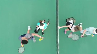 Sona eren tenis oyuncuları ağ değiş tokuş kutusuna doğru yürürken su şişesi geri dönüyor. Sportmenlik, takım çalışması, rekabet, açık hava, atletik, canlı, dostluk