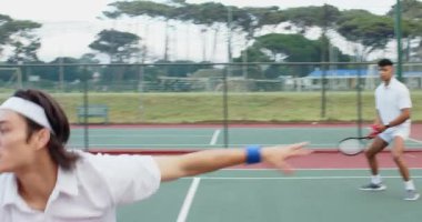 Çeşitli erkek takım arkadaşları, tenis kortunda voleybol antrenmanı yapıyor. Talim üstüne el sıkışıyorlar. Sporcular, antrenman, atletizm, sportmenlik, açık hava, aktif, rekabetçi