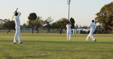 Gardiyan erkek vurucu, sopa sallıyor, saha oyuncusu topu parktan alıyor, kopyalama alanı. Atletizm, takım çalışması, spor, açık hava, rekabetçi, aktif, eğlence