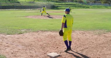 Beyazların birinci kalecisine top atan atıcılar parktaki eldivenleri yakalıyor. Atletik, takım çalışması, aksiyon, açık hava, canlı, rekabetçi, spor