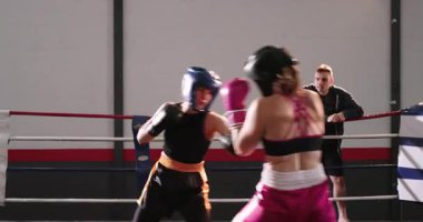 Kadın boksörler, koç ringe çıkıp yumrukları öğretmeden önce ışık altında yumruk atarlar. Eğitim, fitness, agresiflik, odaklanma, spor salonu, rekabet, disiplin