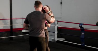 Vites değiştiren eldivenler, koç pembe eldivenli kadın stajyer eğitmeni ringde kombine rehberlik, kopyalama alanı. Eğitim, spor, güç, hareket, motivasyon, atletik, performans