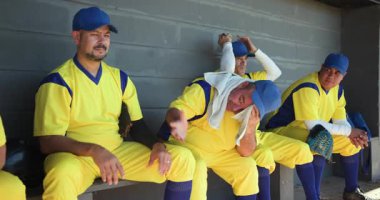 Çılgın takım arkadaşına, yedek kulübesinde oturan farklı kollara sahip takım arkadaşlarını eldivenleriyle kaldırmasına tepki veriyor. Sporcular, yoldaşlık, yüzleşme, takım ruhu, klasik, açık hava, rekabetçi