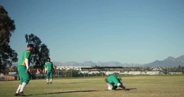 Dış sahaya atılan topa tepki veren erkek takım arkadaşları dalıyor, sarılıyor, üniformalarla kutluyor. Sporcular, takım çalışması, açık hava, aktif, yoldaşlık, sportmenlik, zafer