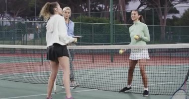 Çeşitli kadın oyuncular topları fırlatıyor. Alacakaranlıkta sahada voleybol antrenmanına başlıyorlar. Koç tableti not ediyor. Atletik, takım çalışması, fitness, eğitim, açık hava, aktif, motive edici