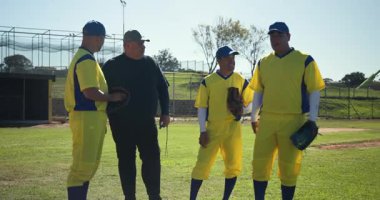Erkek antrenör ve 3 oyuncu beyzbol eldivenleriyle sırayla sahada toplanıyor. Atletik, takım çalışması, motivasyon, açık hava, spor, yoldaşlık, enerjik