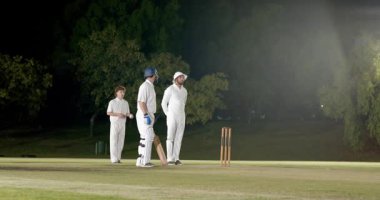 Sinyal gönderen top atıcısı ışıkların altında koşuyor ve kaleye nişan alarak kırmızı topu fırlatıyor. Spor, eğlence, atletik, açık hava, rekabet, gece vakti, hareket