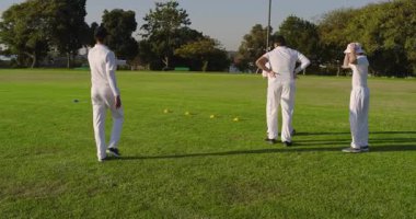 Kriket sahasında koniye yaklaşan beyaz erkek sporcu dört koni boyunca antrenman yapıyor. Sporcular, antrenmanlar, spor, teknik, açık hava, takım çalışması, disiplin