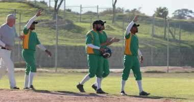 Son sınıf hakemi geçtikten sonra beş farklı erkek beyzbol oyuncusu sahada el çırpıyor, birbirlerine sokuluyorlardı. Atletizm, takım çalışması, dostluk, sportmenlik, açık hava, enerjik, zafer