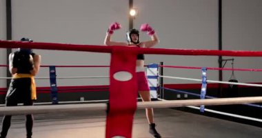 Pembe eldivenli boksör, ring vagonunda kollarını kaldırarak diz çökmüş, kucaklaşan rakip. Atletik, güçlendirme, rekabet, güç, kararlılık, takım, motivasyon