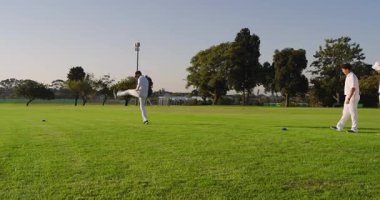 Erkek bovling oyuncusunun sahadaki külahlarda koşmasına, ters bovling oynamasına ve pas vermesine tepki veriyor. Sporcular, antrenmanlar, spor, açık hava, takım çalışması, atletizm, dinamik