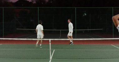 Asyalı oyuncu miting düzenliyor, Afrika kökenli Amerikalı adam kollarını kaldırarak kazananı eziyor. Sporcular, rekabet, takım çalışması, aktif, sportmenlik, açık hava, canlı