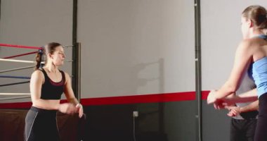 Koç antremanından sonra, kadın stajyerler beden eğitimi için sırayla ağır atlama ve çömelme hareketleri yapıyor. Eğitim, güç, fitness, atletik, egzersiz, performans, dinamik