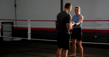 Sargıları açmak, boks eldivenlerini takmak, antrenman için antrenörlere rehberlik etmek. Eğitim, fitness, boks, koç, atlet, takım çalışması, disiplin