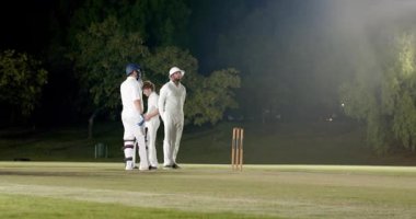 Çeşitli kriket oyuncuları, engelli bovling sahasında top vurucusunu araştırıyor. Spor, takım çalışması, rekabet, açık hava, atletik, canlı, dinamik