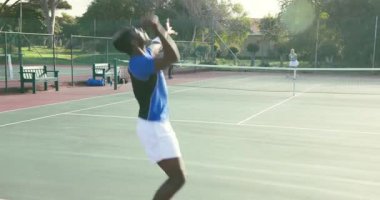 Koç, Afro-Amerikan oyuncuları çağırıyor. Spor giyim bölümünde. Fotokopi alanının yanında voleybol oynuyor. Atletik, rekabetçi, açık hava, stratejik, enerjik, eğitimli, hassas