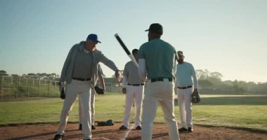 Kıdemli koç, şafak vakti kale levhasını ayarlamak için sopaya vuruyor. Atletizm, sportmenlik, takım çalışması, antrenman, açık hava, enerjik, disiplinli