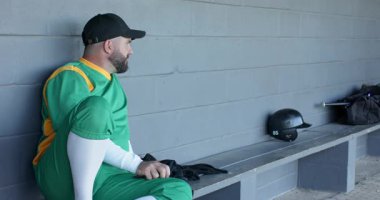 Çeşitli erkek oyuncular yedek kulübesine beyzbolla giren takım arkadaşına hoş geldin diyor, hazırlanırken beşlik çakıyor. Sporcular, takım çalışması, yoldaşlık, sportmenlik, gündelik, kentsel, enerjik