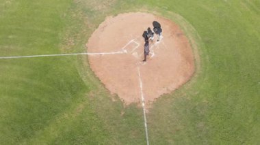 Top geliyor, beyaz erkek vurucu sopa sallıyor, sopa kayıyor, elmasta 1. kaleye koşuyor. Spor, eğlence, aksiyon, açık hava, atletik, rekabet, takım çalışması