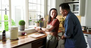 Olgun bir çift modern mutfakta yemek pişiriyor, tahta ve çatal bıçak üzerinde sebze hazırlıyor. Aşçılık, mutfak, çift, hazırlık, aşçılık, modern, yaşam tarzı