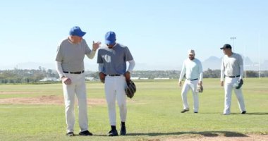 Sahaya ulaşıyor, kıdemli koç atıcı öğretiyor takım eldivenle topu yakalamadan önce attığı adımları atıyor. Akıl hocalığı, takım çalışması, eğitim, sportmenlik, rehberlik, atletizm, strateji