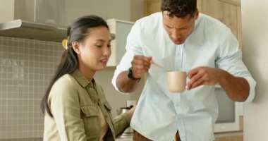 Mutfak adasındaki çeşitli çiftler kahve yapmaya başlarken erkekler kavanozu boşaltıyor ve kadınlar akıllı telefon gösteriyor. Modern, samimi, samimi, yaşam tarzı, sıcak, dost canlısı, etkileşim