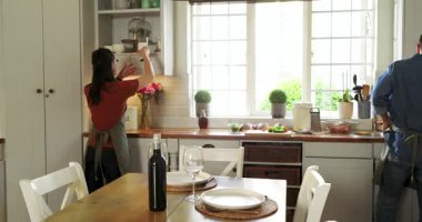 Asyalı olgun bir adam modern mutfakta tencere ve çatallarla makarna pişiriyor, kopyalama alanı. Aşçılık, aşçılık, mutfak, malzemeler, hazırlık, ev yapımı, gurme