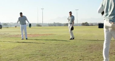 Çeşitli erkek takım arkadaşları sahada eldivenlerle topu yakalayıp geri getirerek ısınma talimine başlıyorlar. Atletizm, takım çalışması, eğitim, açık hava, aktivite, sportmenlik, enerji