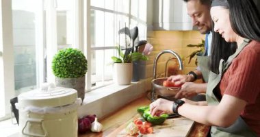 Asyalı çift ahşap tezgahta havuç ve biber doğruyor, duruluyor, tatma, kopyalama alanı. Mutfak, takım çalışması, kırsal, taze, yerli, mutluluk, işbirliği