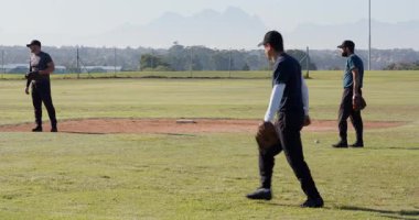 Çimlere çıktıktan sonra, erkek oyuncular atıcının tepesinde ısınmadan önce yakalayışırlar. Atletizm, takım, spor, rekabet, açık hava, aktivite, eğitim