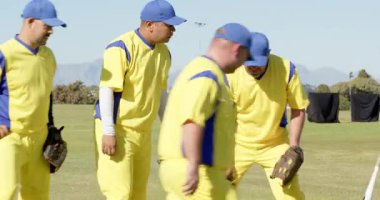 Ortadaki erkek beyzbol takımına doğru yürüyoruz oyun öncesi çimenlerin üzerinde toplanıyoruz, beyzbol eldivenlerini yarasanın üzerine yığıyoruz. Takım, yoldaşlık, birlik, açık hava, atletik, spor, rekabet