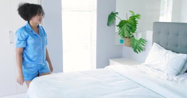 Yatak odasındaki çeşitli çiftler yastıkları yumuşatmak için çarşafları kabartmak için yorgan örterek yatak hazırlıyorlar. Romantizm, samimiyet, evcil, rahatlama, uyum, minimalist, samimi