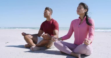 Çeşitli çiftler meditasyona kumsalda derin derin nefes alarak ve yavaşça nefes vererek başlarlar. Dinginlik, farkındalık, sağlık, sahil, sükunet, uyum, rahatlama.