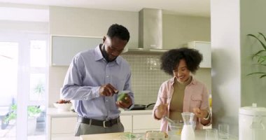 Çeşitli çiftler sohbet ediyor, yumurta çırpıyor, ada tezgahında avokado dilimliyor kahvaltı hazırlıyorlar. Aşçılık, aşçılık, hazırlık, modern, yaşam tarzı, takım çalışması, taze