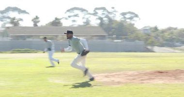 Başlangıç olarak, erkek atıcı beyzbolu bırakıyor, yakalayıcı iç sahada yakalayıp kutluyor. Atletik, takım çalışması, rekabetçi, spor, açık hava, enerjik, hareket