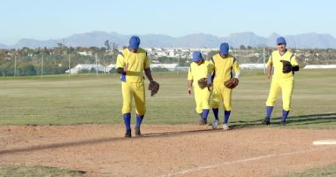 Sahanın dışından iç kesimlerine doğru eldivenlerle yürüyen erkek oyuncular oynadıktan sonra arkadaşlığı kutluyorlar. Atletizm, takım çalışması, yoldaşlık, spor, açık hava, boş zaman, enerjik