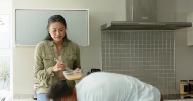 Çeşitli çiftler mutfakta omlet pişiriyor yumurta pişiriyor sonra tavaya yağ ve yumurta döküyorlar. Yemek pişirme, takım çalışması, modern, aşçılık, kahvaltı, işbirliği, yaşam tarzı