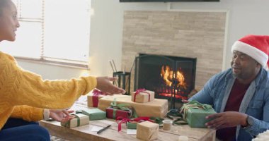 Kadın kurdeleyi evde ayarlamadan önce Afrikalı Amerikalı bir adama hediye verdikten sonra. Kutlama, sıcak, samimi, kutlama, samimiyet, tatil, gelenek