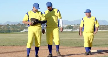 Çeşitli erkek takım arkadaşları eldiven değiş tokuşu yapıyor sonra da tükenmiş oyuncunun elmas üzerinde eğilmesine yardım ediyor. Sporcular, takım çalışması, yoldaşlık, açık hava, sportmenlik, zafer, kararlılık