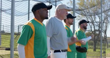 Başarılı bir oyunu kutluyoruz, çeşitli takım arkadaşları üniforma giyip takım için çitlerde eldiven çırpıyorlar. Atletizm, yoldaşlık, takım çalışması, sportmenlik, açık hava, hareketli, aktif