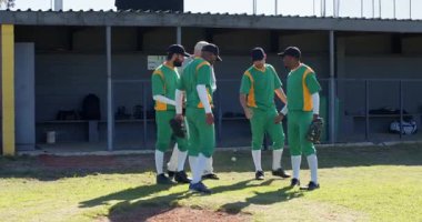 Höyüğe adım atan, yeşil-sarı üniformalı farklı takımlar eldiven takan, tezahürat yapan, koşan. Atletizm, takım çalışması, yoldaşlık, spor, açık hava, motivasyon, birlik