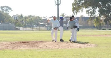 Sahada erkek takım arkadaşlarını kaydediyor ve top yakalayıcı viteste beşlik çakıyor, vurucunun elini sıkıyor. Sporcular, takım çalışması, spor, rekabetçi, enerjik, açık hava, yoldaşlık