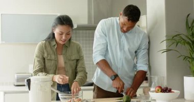 Yumurta, avokado dilimleyen ve kahvaltıyı hazırlayan çeşitli çiftler. İşbirliği, mutfak, yerli, modern, neşeli, sağlıklı, sağlıklı