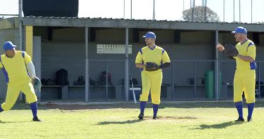 Sağ takım arkadaşı topu fırlatırken olgun erkek atıcı, eldiven ile tümsekte pozisyon değiştiriyor. Atletik, takım çalışması, rekabet, rekabet, açık hava, dinamik, hareket