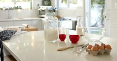 Pan başlıyor, kamera un boyunca sola hareket ediyor, yumurta çırpma tezgahta, ev mutfağını gösteriyor. Pişirme, pişirme, aşçılık, modern, rahat, evcil, pastel