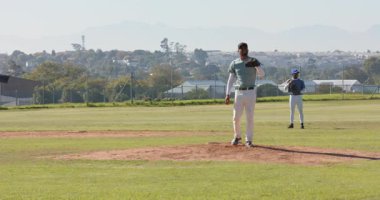 Vuruş için hazırlanan Afro-Amerikan atıcı dizini kaldırıyor, top tümseğe doğru ilerliyor. Atletizm, spor, yoğunluk, konsantrasyon, takım çalışması, açık hava, dinamik