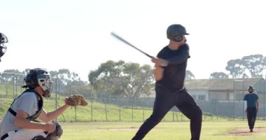 Atıcının topu atması erkek vurucunun sopayı sallamasına ve ıskalamasına, tutucunun eldiveni sahada güvene almasına neden oldu. Atletizm, spor, rekabet, eylem, takım çalışması, açık hava, enerji